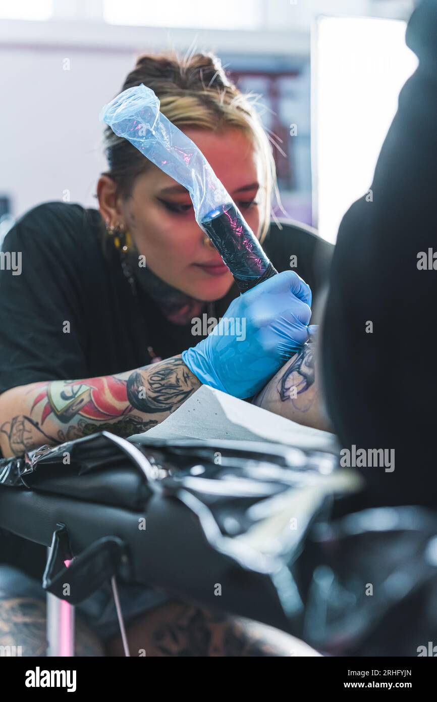 Focused Female Tattoo Artist Drawing A Tattoo On Her Client Leg Tattoo Focused Female Tattoo Artist Drawing A Tattoo On Her Client Leg Tattoo