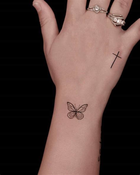 Little Butterfly And Cross Tattoos Located On The Wrist